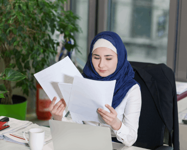 A translator edits an English to Arabic contract on a laptop, providing Arabic Translation Services in Illinois for language.